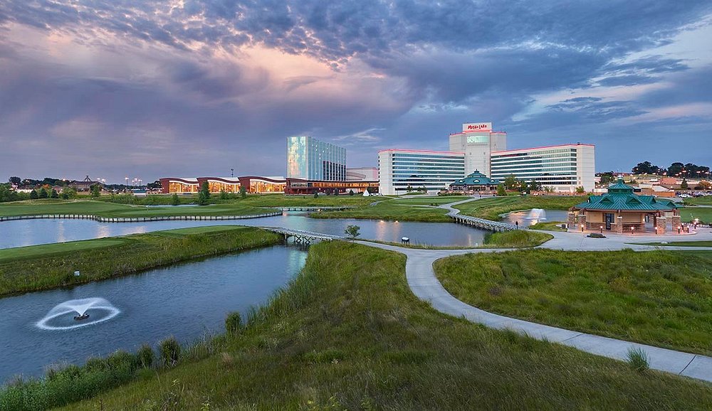 The Mystic Lake Casino Hotel can be seen in the background. In the foreground, there are walking paths that trail across a meadow with ponds.